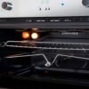 Interior iluminado del horno Challenger HG9763 con las parrillas puestas