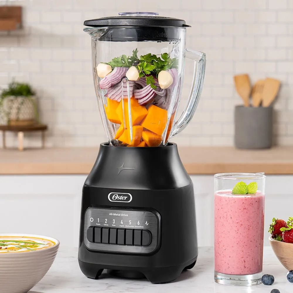 Licuadora Oster negra de 6 velocidades con verduras y batido en la cocina