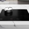 Cubierta de inducción Whirlpool ACM807BA en uso, con olla sobre la superficie