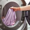 Persona sacando toalla seca de secadora Whirlpool gris