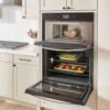 Torre de hornos Whirlpool WOEC7027PZ instalada en cocina con horno y microondas en uso