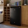 Minibar Electrolux 122 litros negro instalado bajo mueble de sala