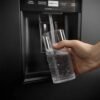 Dispensador de agua en la puerta del nevecón Electrolux ERS45F3C5EB sirviendo agua fría en un vaso