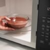 Horno microondas Whirlpool 45 L calentando alimento con sensor de cocción